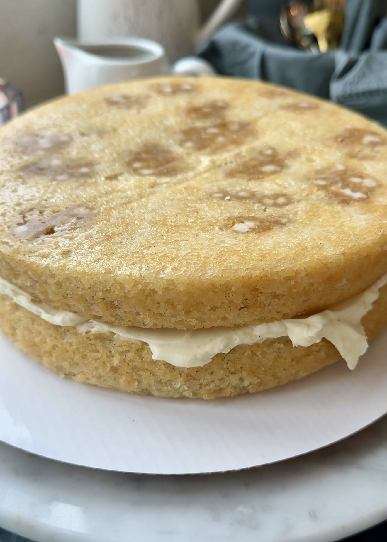 Two blondie cake layers stacked with cheesecake frosting and caramel