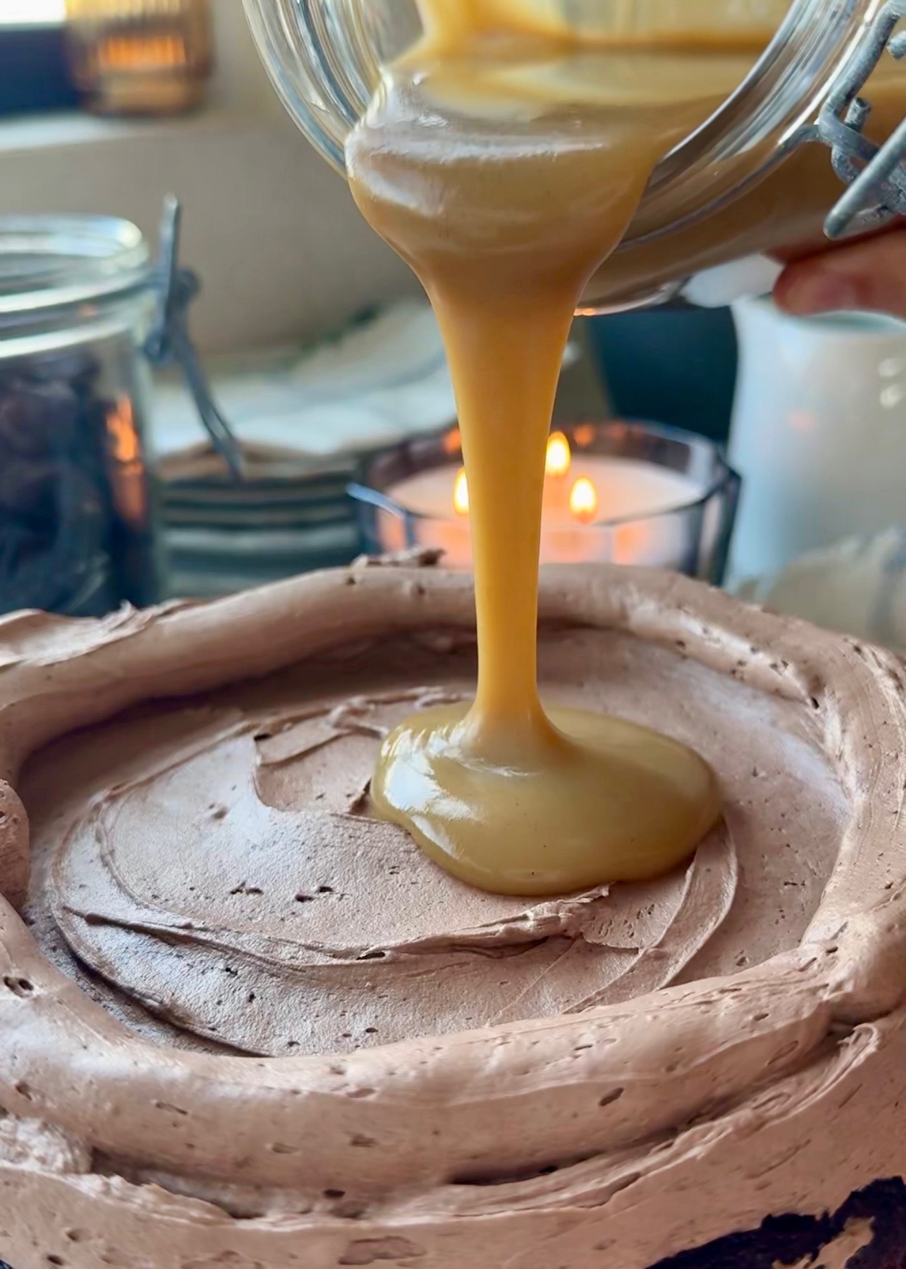 Salted brown sugar caramel pouring into a chocolate buttercream dam