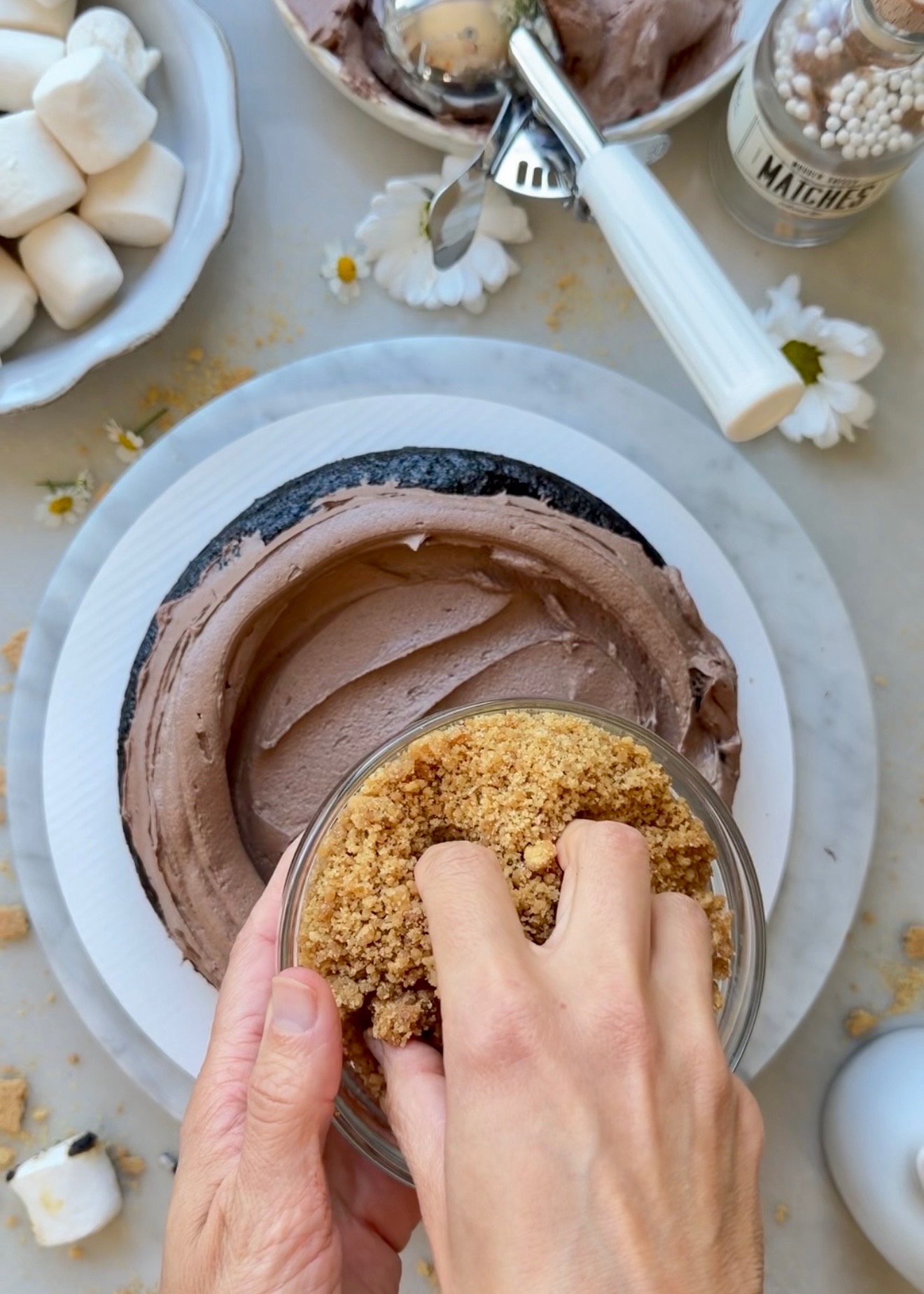 Golden Oreo crunch being scattered over chocolate buttercream inside S’mores Lava Cake