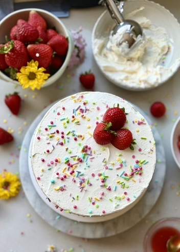 Finished strawberry shortcake cake batter cake topped with strawberries and rainbow sprinkles