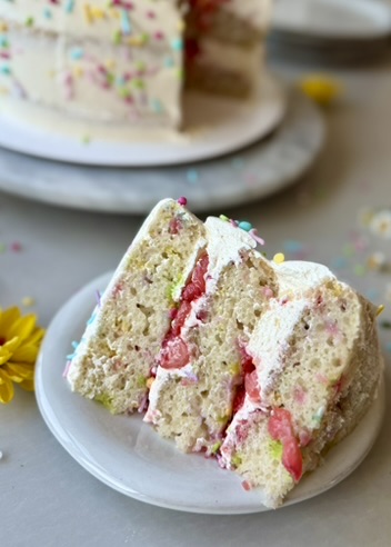 Slices of strawberry shortcake cake batter cake showing strawberries and sprinkle cake layers