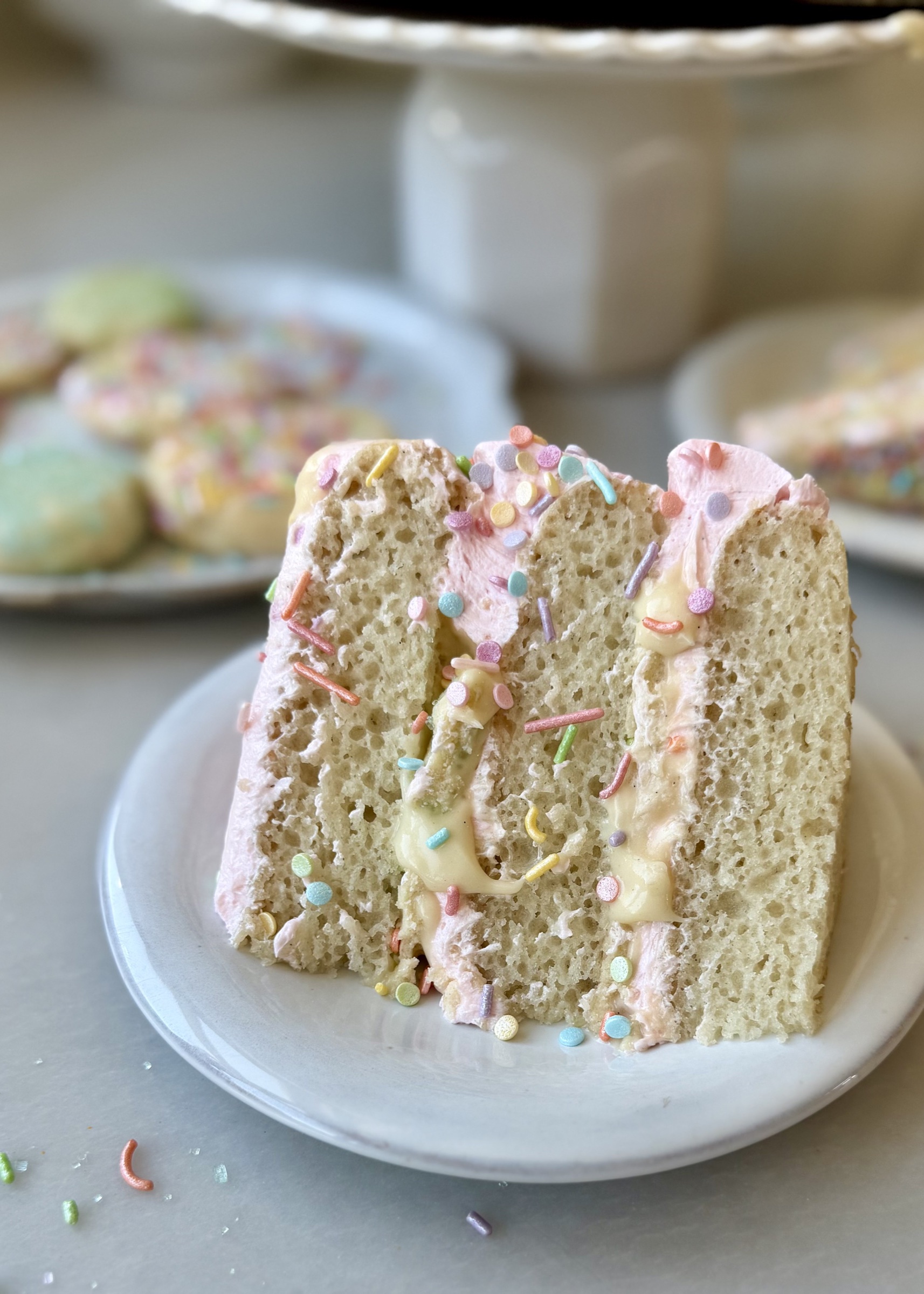 Slice of Sugar Cookie Lava Cake showing vanilla cake, pink buttercream, and flowing cookie lava