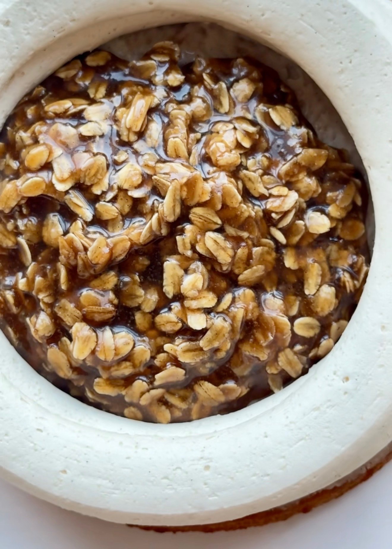 Close view of glossy oatmeal caramel filling inside a buttercream dam