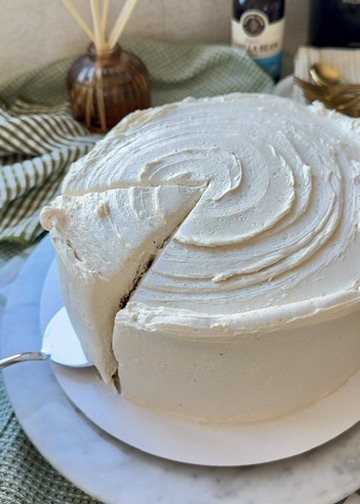 The first slice being cut from a vanilla bean cake with swirled buttercream