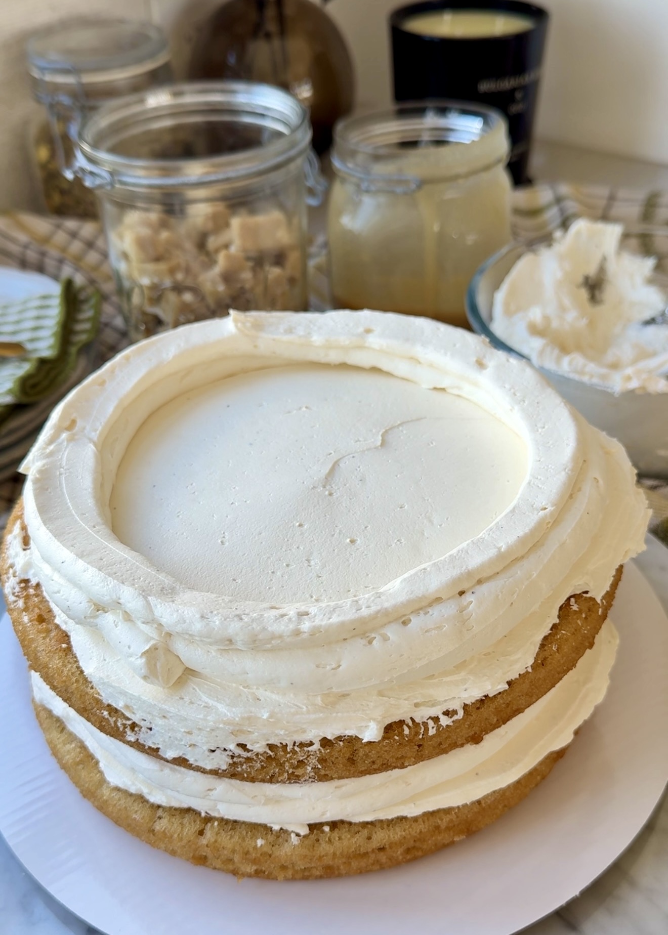 Two vanilla cake layers stacked with tall buttercream dams
