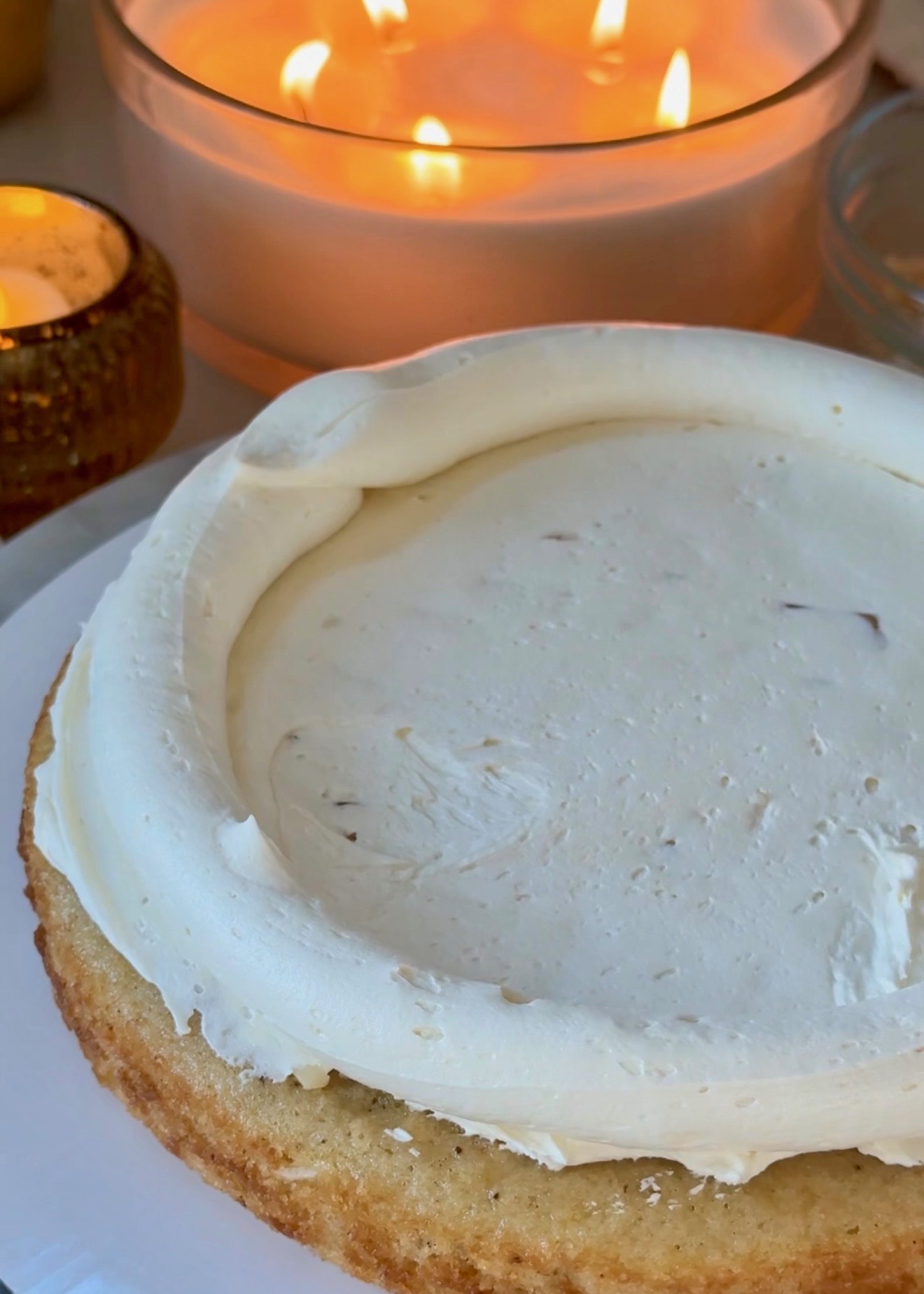 Vanilla buttercream spread over a macadamia cake layer inside a piped buttercream dam