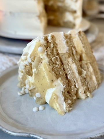 Slice of White Chocolate Macadamia Nut Lava Cake with vanilla lava flowing down the side